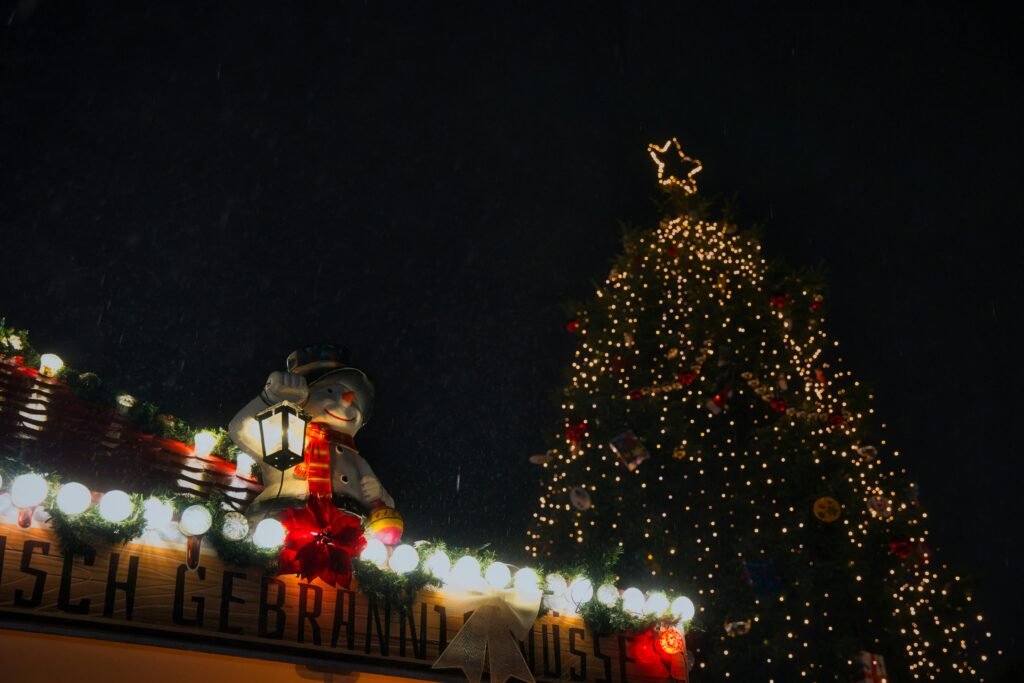 Snowy Christmas market in Oranienburg with lights and a festive snowman decoration.